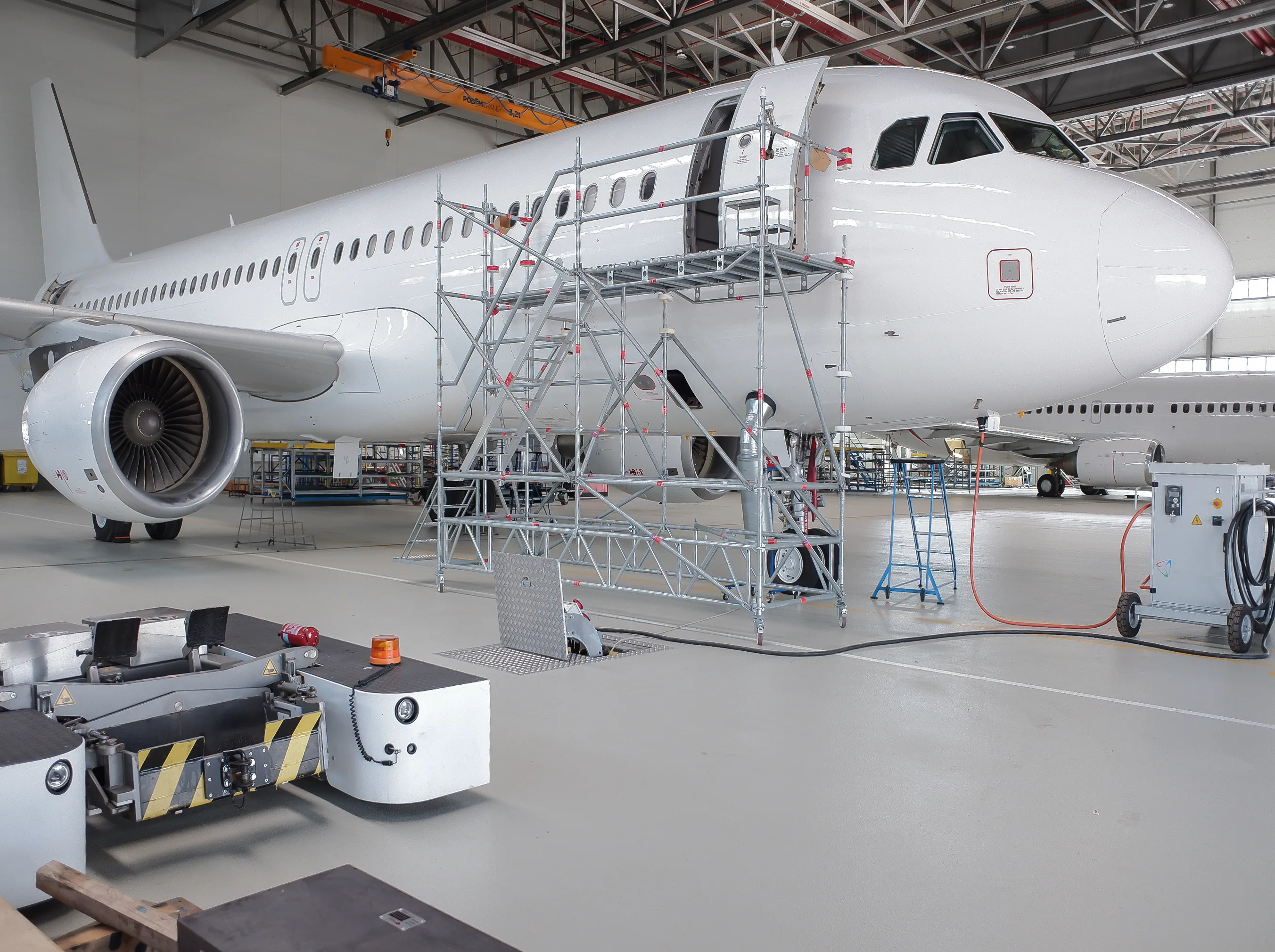 Aircraft in maintenance hangar with ElectroAir underground PIT system and 400 Hz GPU connected for servicing.