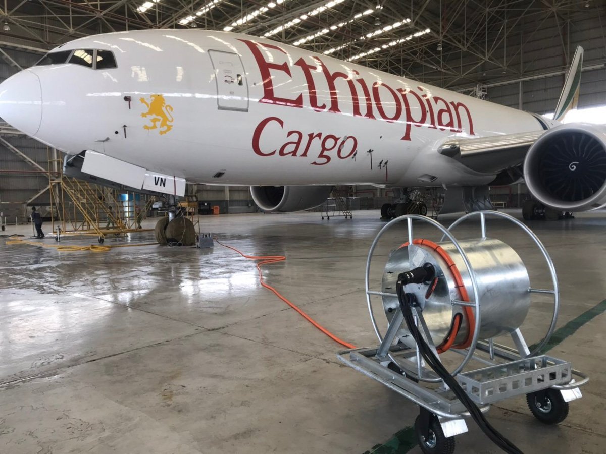 ElectroAir aircraft ground power cable reel connected to Ethiopian Cargo Boeing in hangar