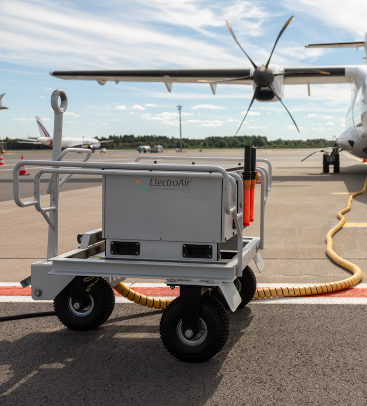ElectroAir EAR-800M connected to a propeller plane on a sunny day at the apron.